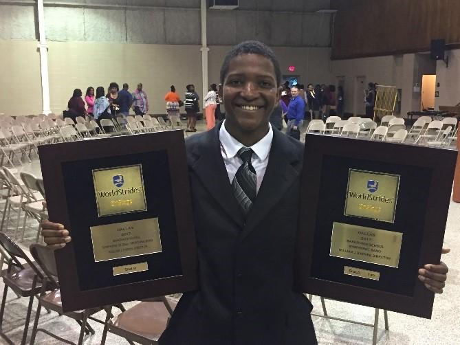 Photo of Robert Harrison showing off with the awards the band won in Dallas, Texas