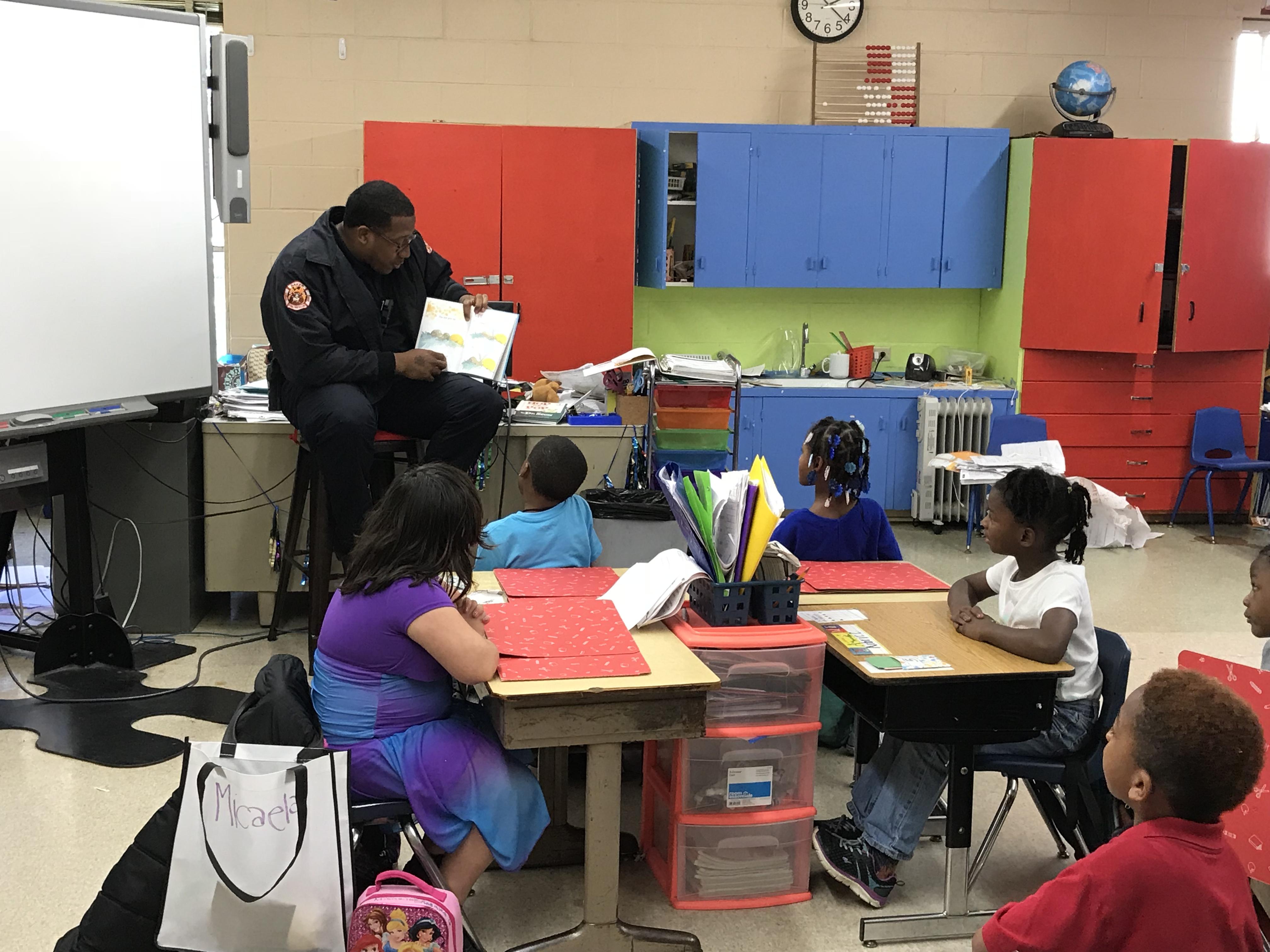 a photo of another member of the Baker Fire Department reading to a classroom of students at Park Ridge Academic Magnet School