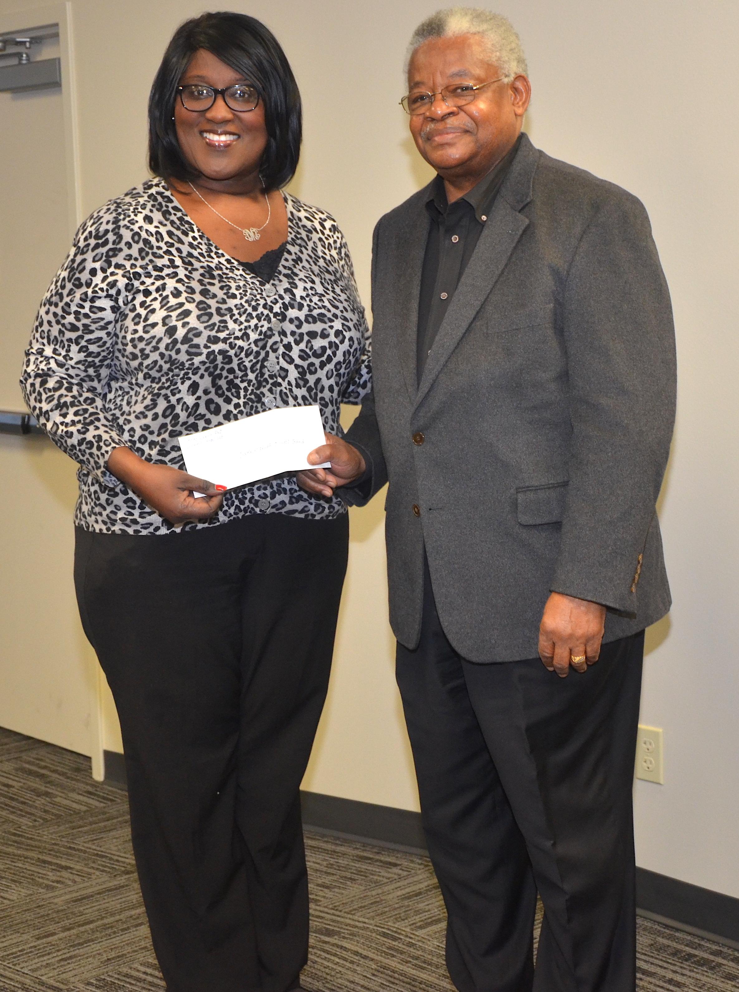 photo of Dr. Leroy Davis presenting $1,000 check to the Baker High Band for Carnegie Trip
