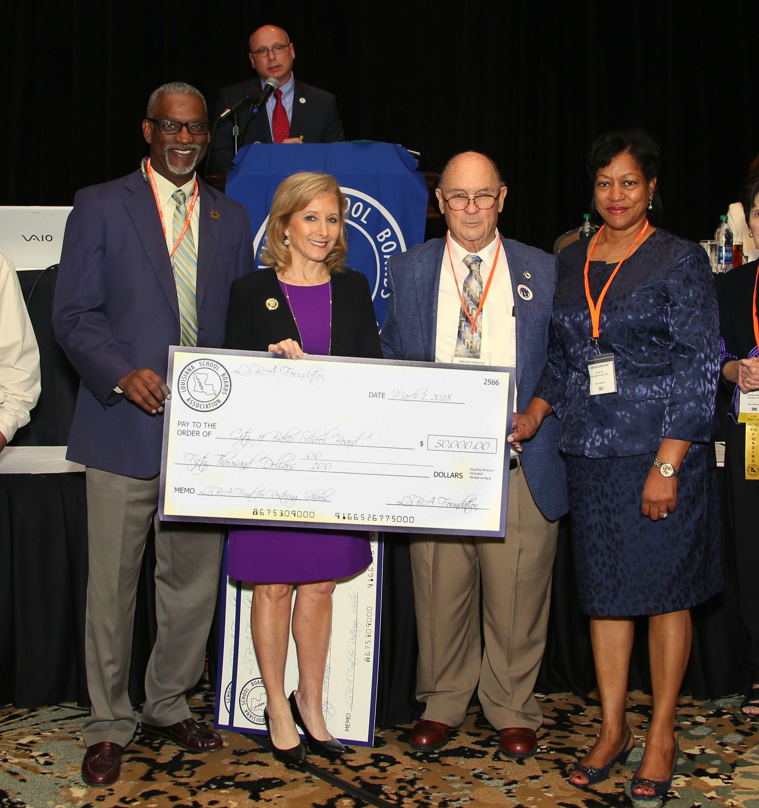 Photo of Superintendent Brister receiving a check for $50,000 at the Louisiana School Board Association's last conference held spring of 2018