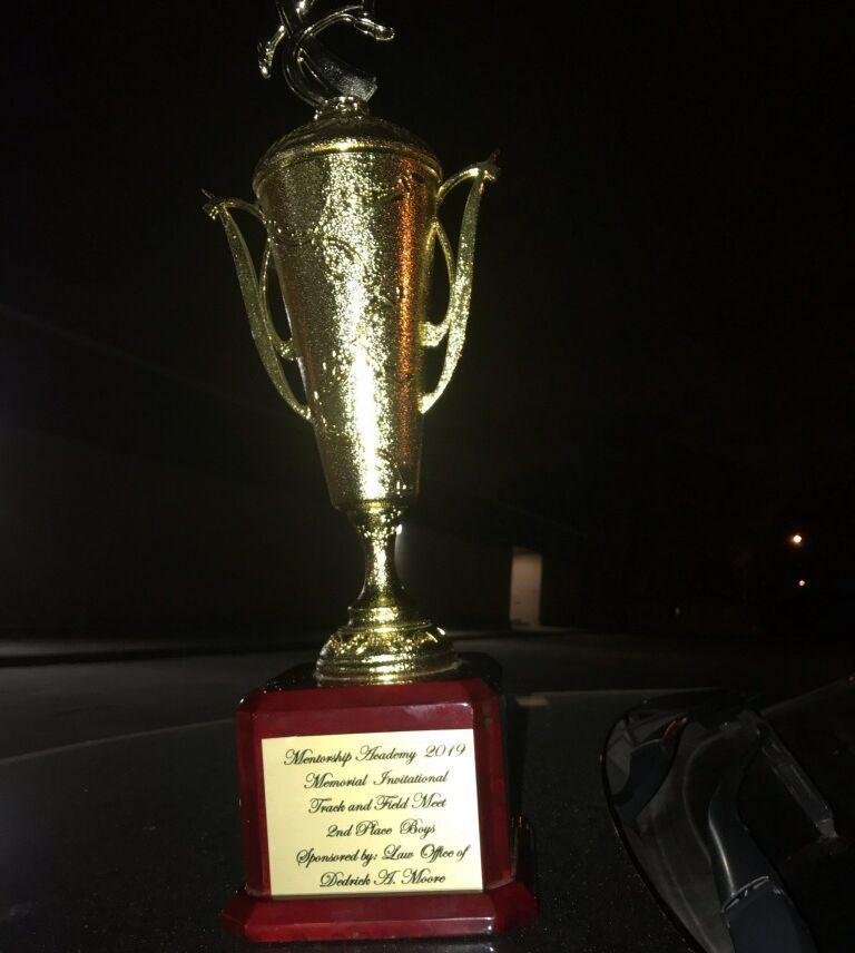  A photo of a trophy that says 2nd Place at the Mentorship Academy 2019 Memorial Invitational Track and Field Meet Sponsored by Law Office of Dedrick A. Moore