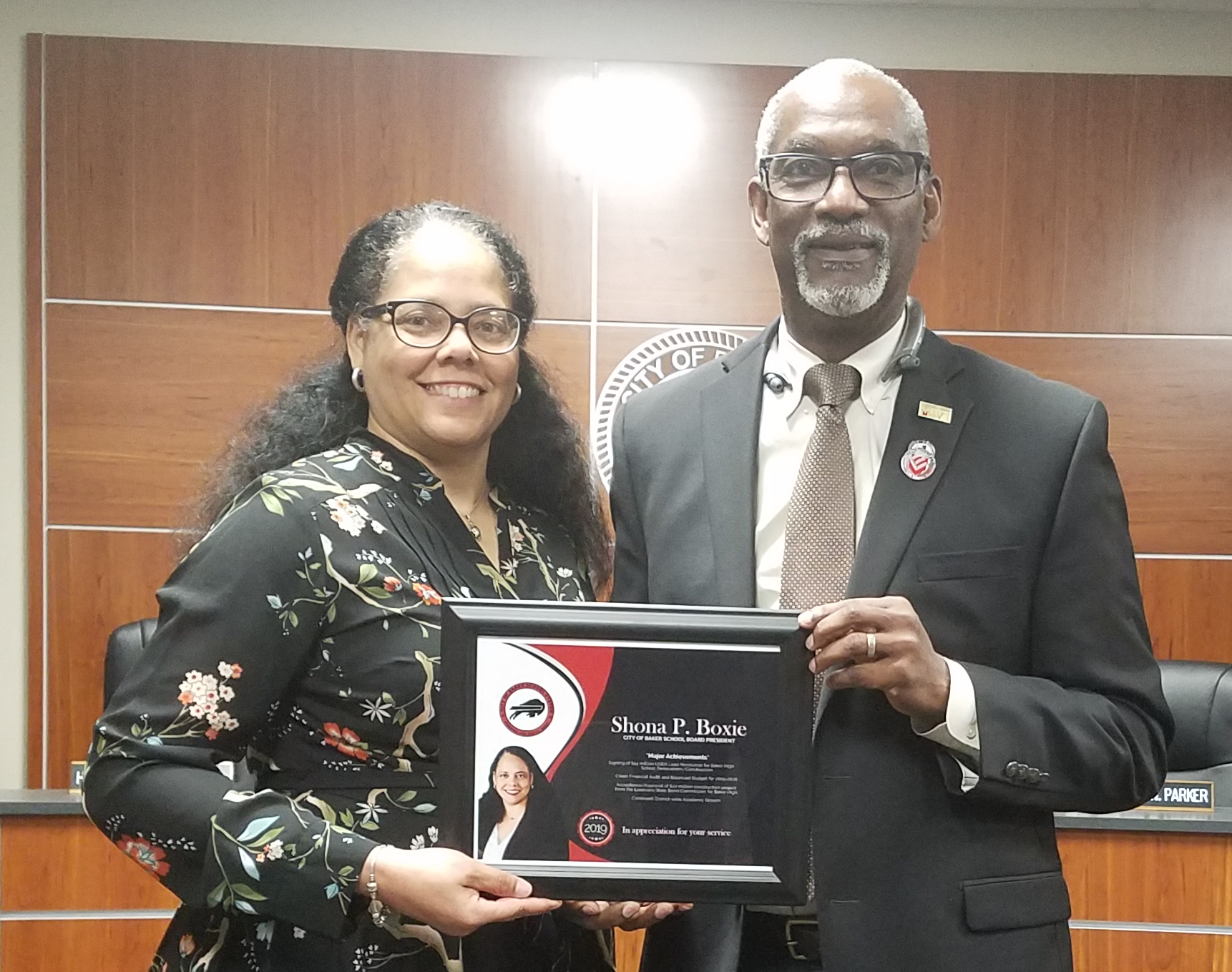 A Photo of Superintendent Brister presenting service award to outgoing Board President, Mrs. Shona Boxie, Esq